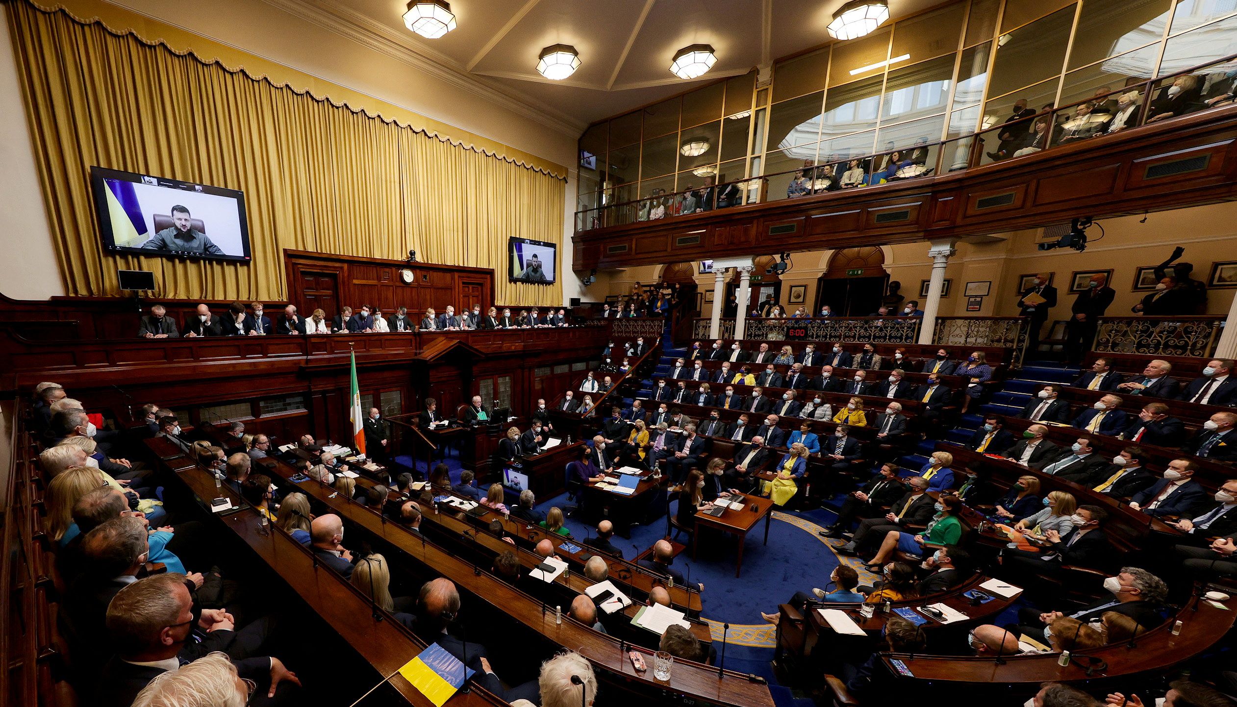 Ukrainian President Volodymyr Zelenskiy addresses on screens via videolink, a joint sitting of both Dail and Seanad Eireann (the Houses of the Oireachtas, Irish Parliament) in the Dail Chamber of Leinster House, in Dublin, Ireland April 6, 2022. Maxwells/Handout via REUTERS
