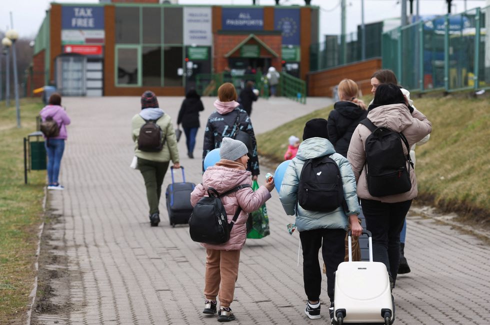 Ukrainian refugees walk towards border crossing from Poland to Ukraine, amid the Russian invasion of Ukraine, in Medyka, Poland, April 6, 2022.  REUTERS/Kacper Pempel