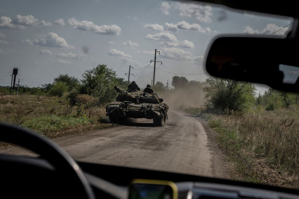 Ukrainian servicemen ride a tank, as Russia's attack on Ukraine continues, near the village of Robotyne