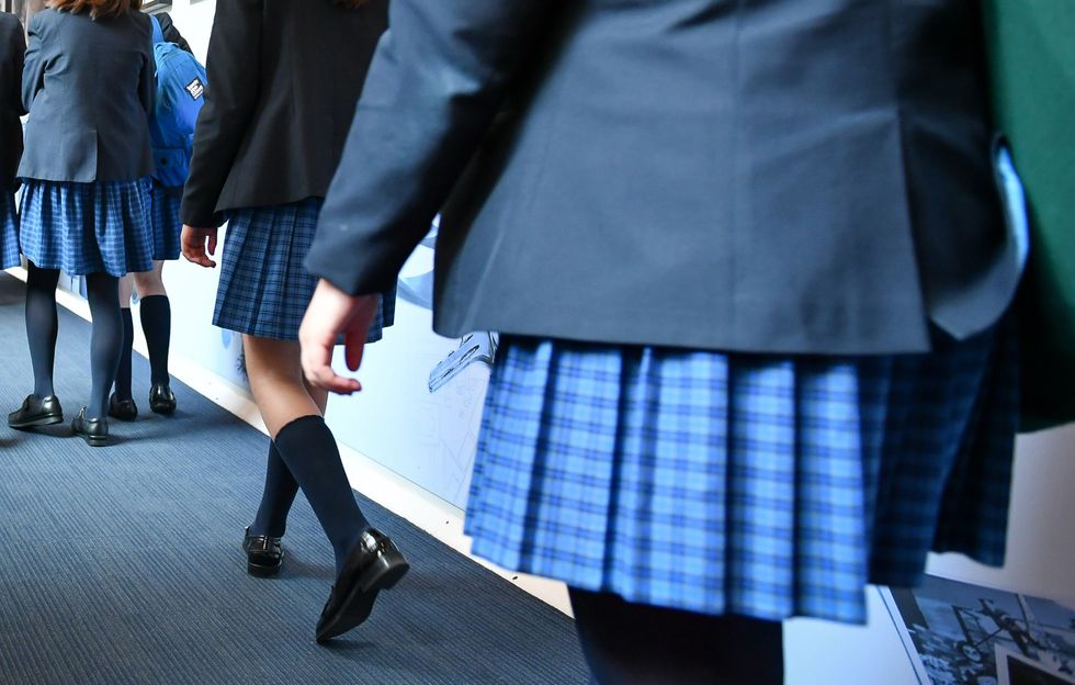 Undated file photo of female students walking along a corridor. One in five girls and young women are teased or bullied over their periods, with many suffering in silence, according to a study.