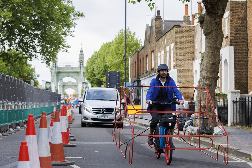 Undated handout photo issued by Dott of a cyclists wearing a frame shaped like a car to demonstrate that vehicles are %22hogging%22 roads. Issue date: Tuesday May 31, 2022.
