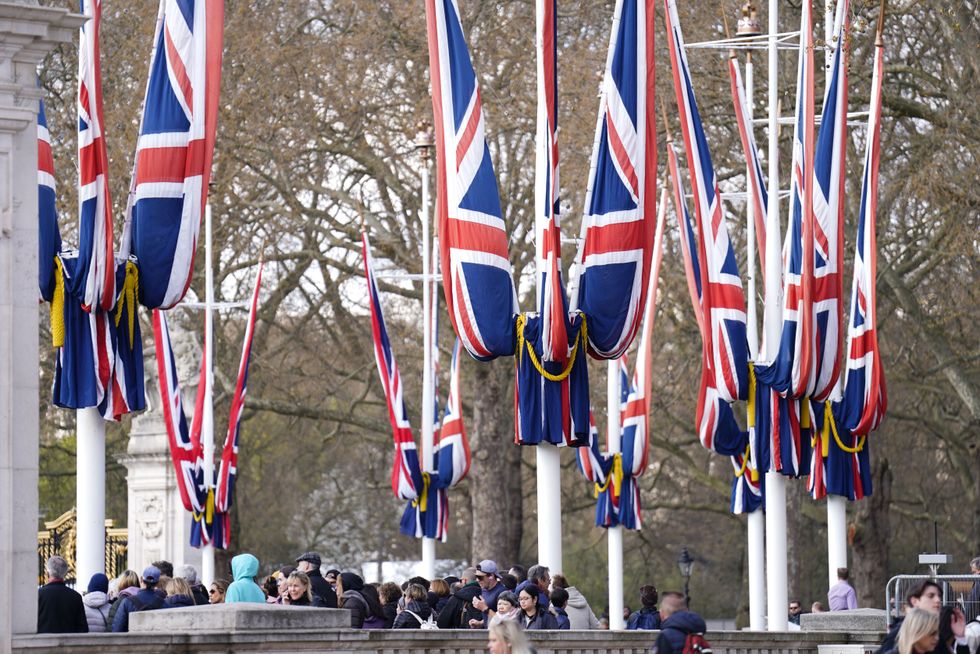 Union Jack flags being hung near Buckingham Palace