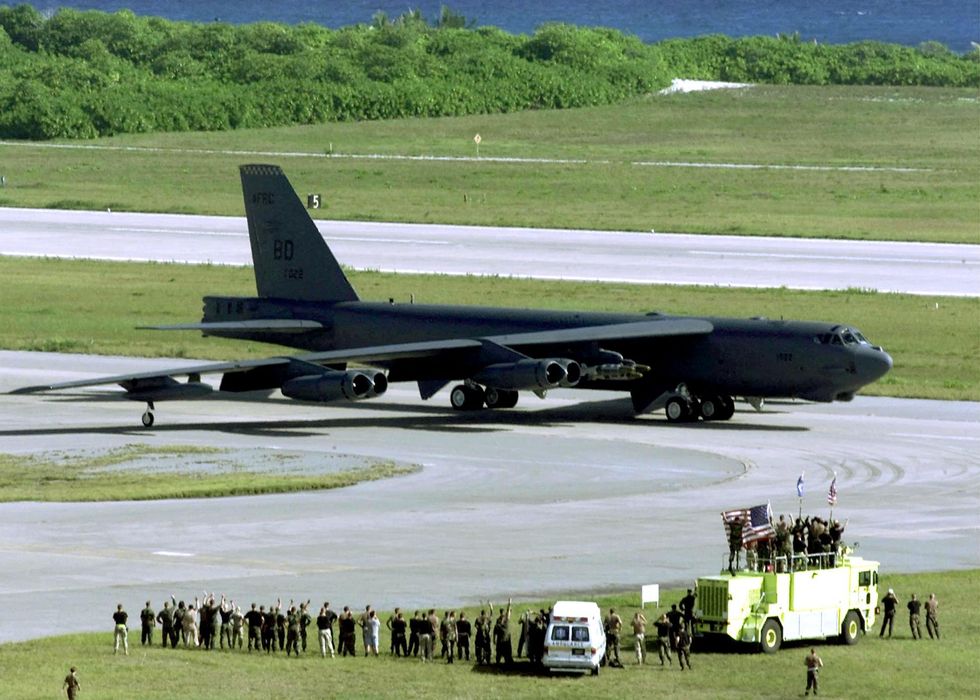 US Air Force ground crew members wave at a B-52H Stratofortress bomber as it taxis in Diego Garcia for take off on a strike mission against Afghanistan 07 October 2001u200b