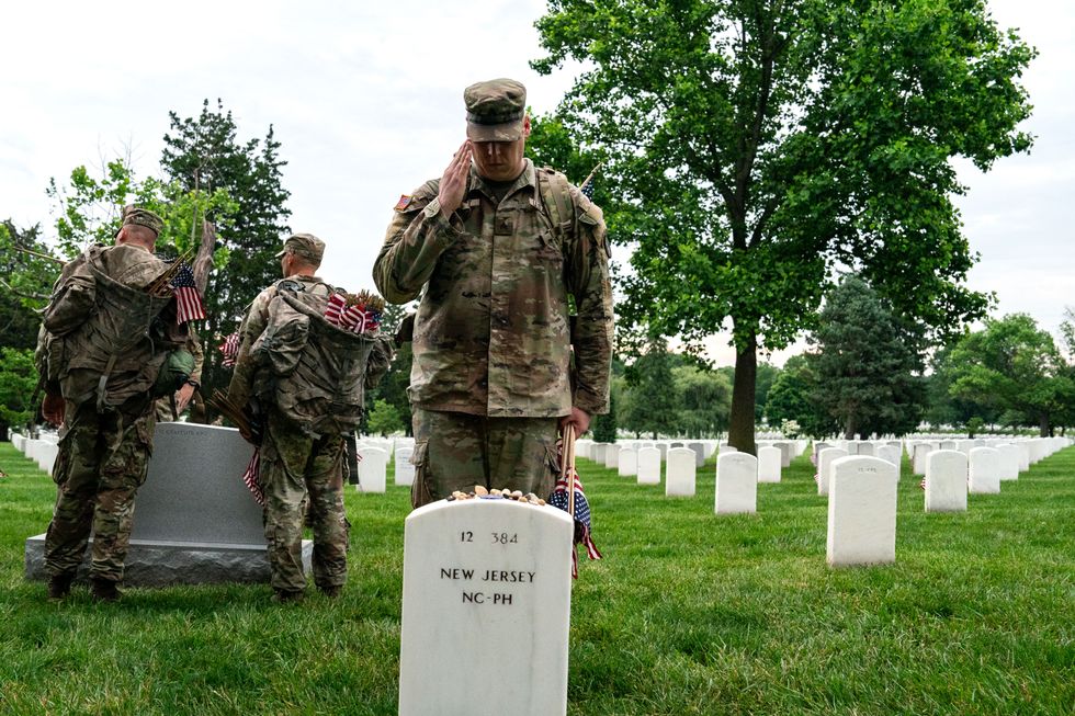 US army soldier saluting grave