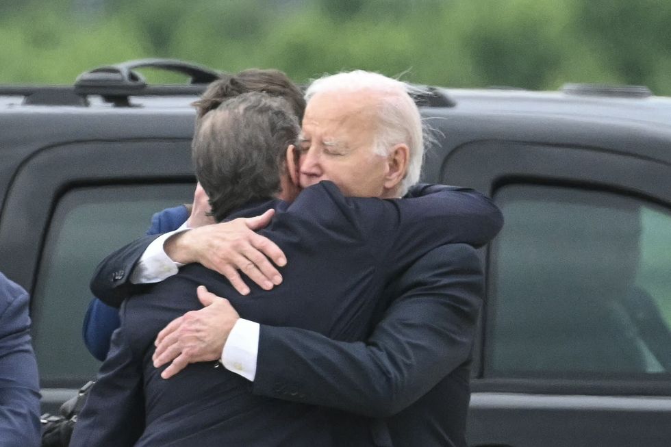 US President Joe Biden hugs his son Hunter Biden upon arrival at Delaware Air National Guard Base