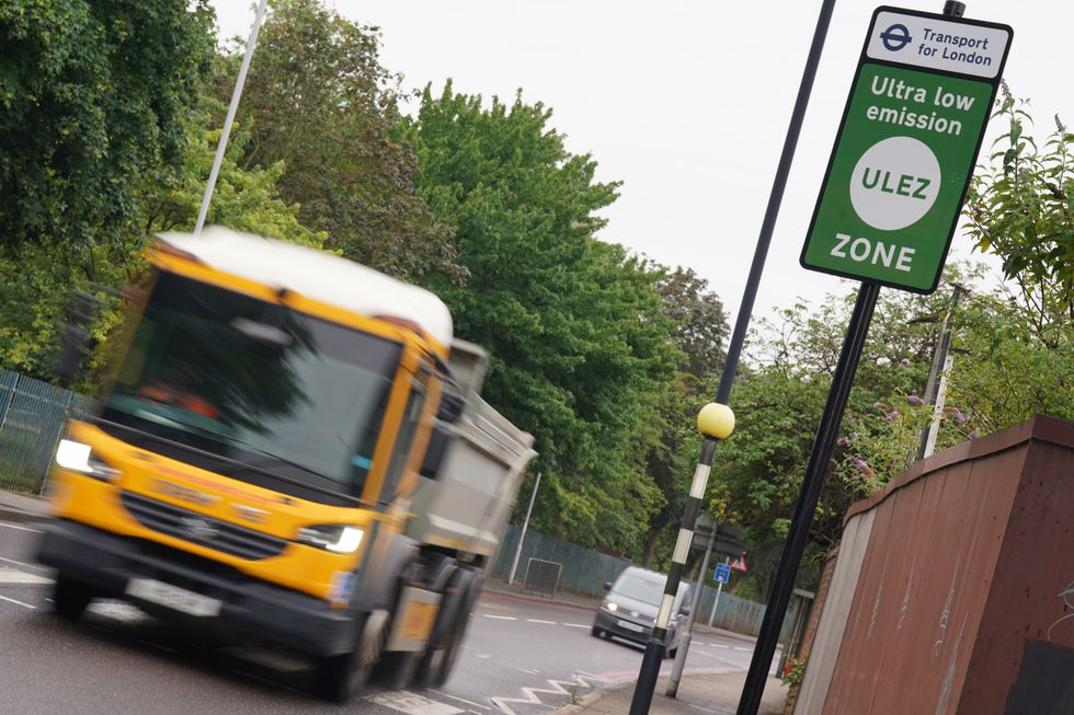 Vehicles driving past a Ulez sign