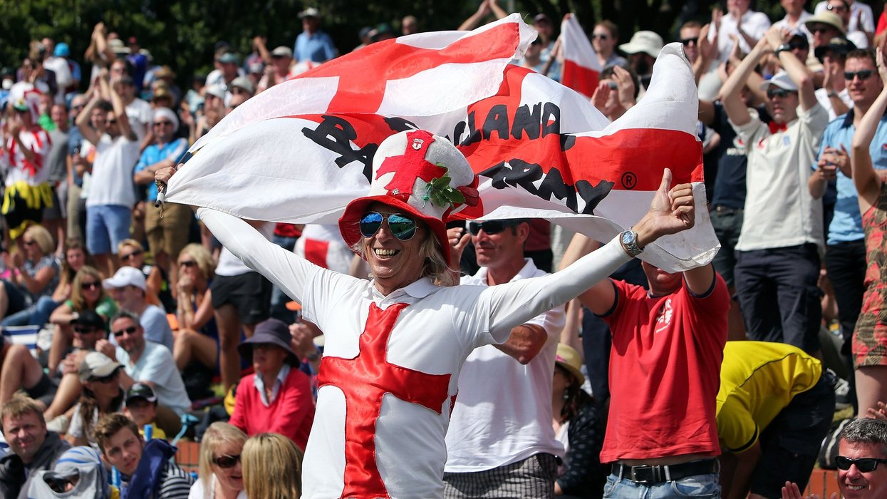 Vic Flowers wearing an English hat and top, holding an English flag supporting the Barmy Army