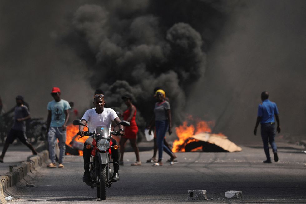 Violence in Haiti, black smoke bellows from a fire in a road