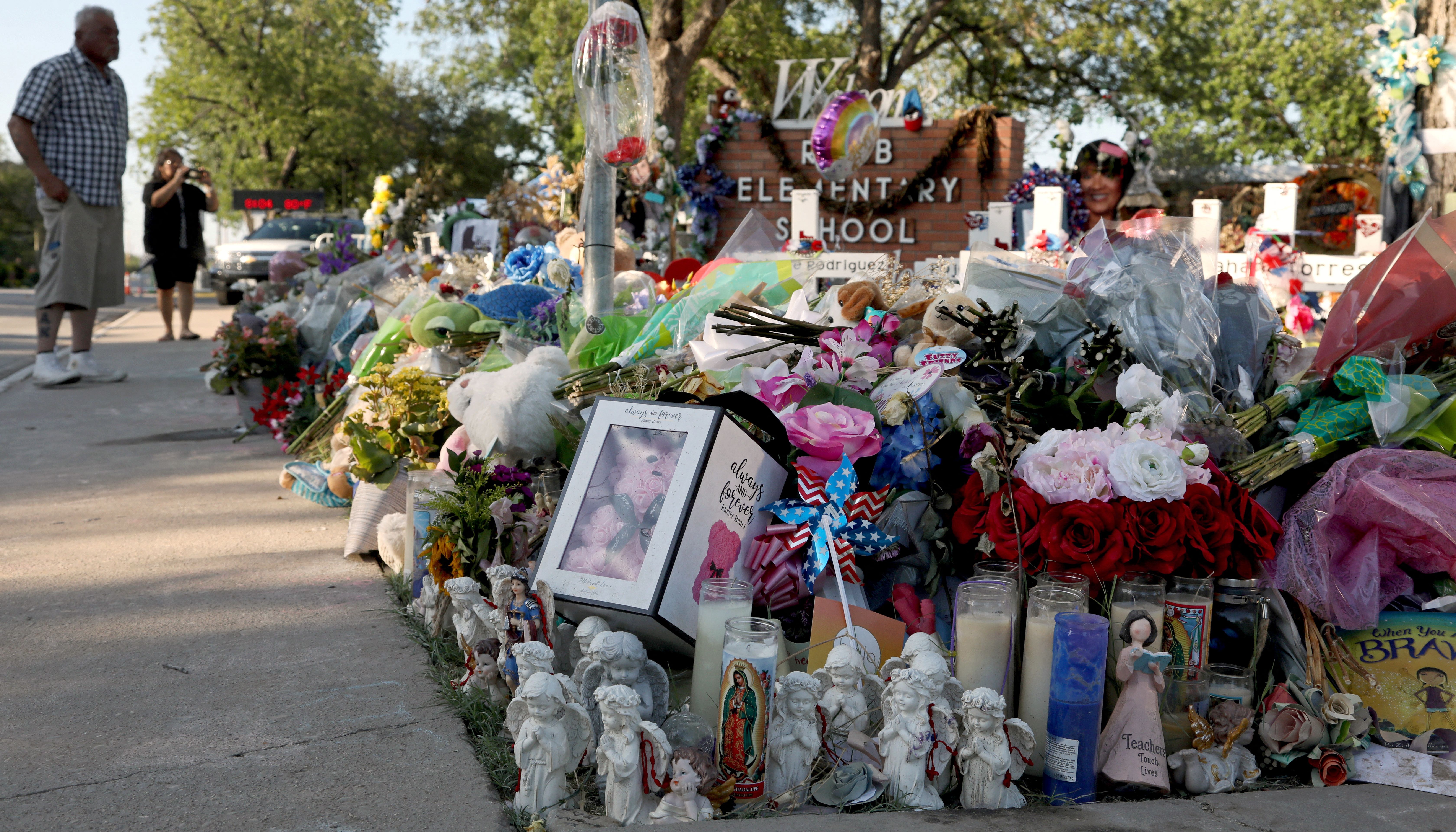 Visitors arrive at the memorial for the shooting victims outside Robb Elementary School early Saturday morning in Uvalde, Texas.