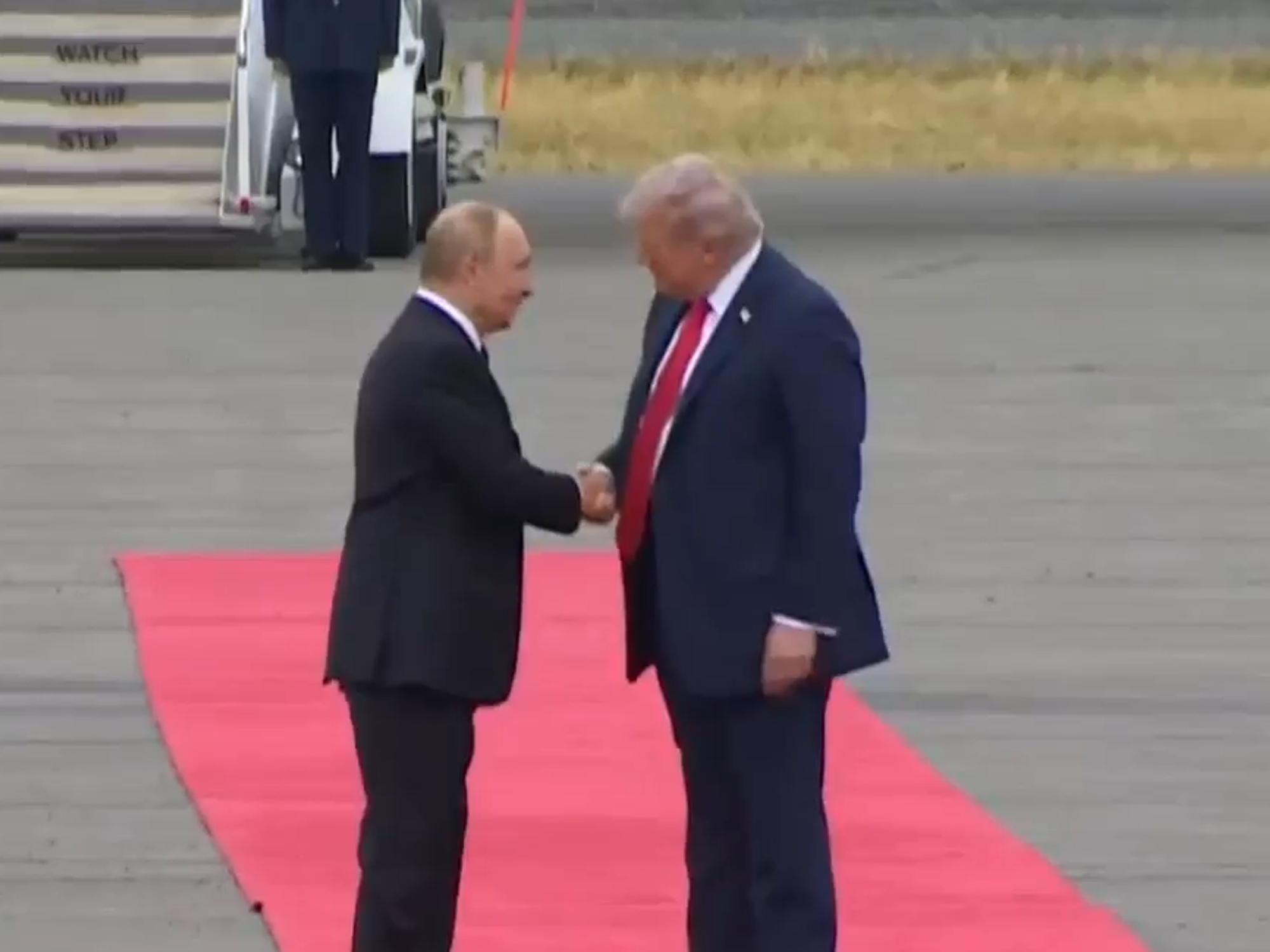 Vladimir Putin and Donald Trump shake hands on the Anchorage tarmac