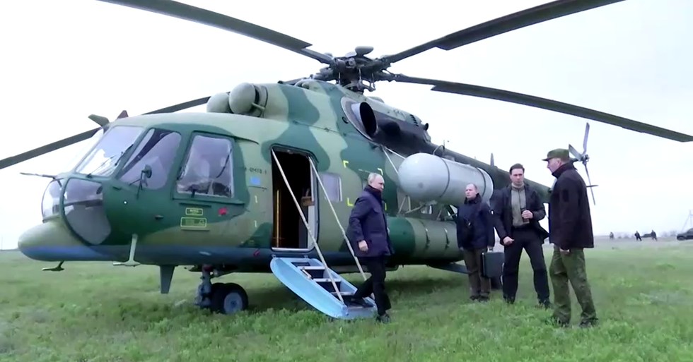 Vladimir Putin exiting a helicopter to meet Russian military chiefs