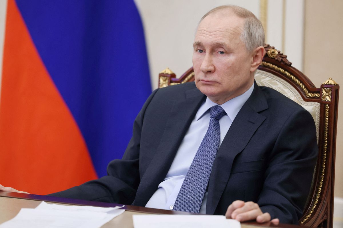 Vladimir Putin sitting at a table