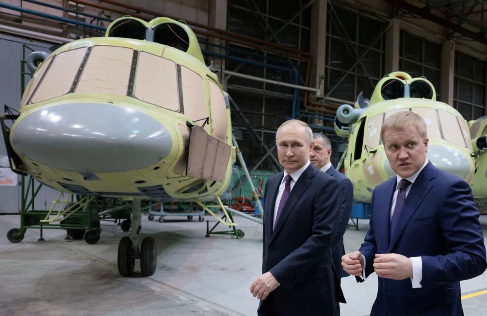 Vladmir Putin is shown round an airforce hangar