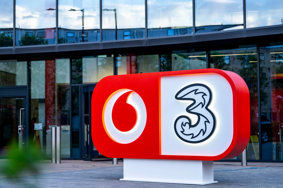 VodafoneThree logo that combines both Vodafone and Three company logo into a single pill-shaped box