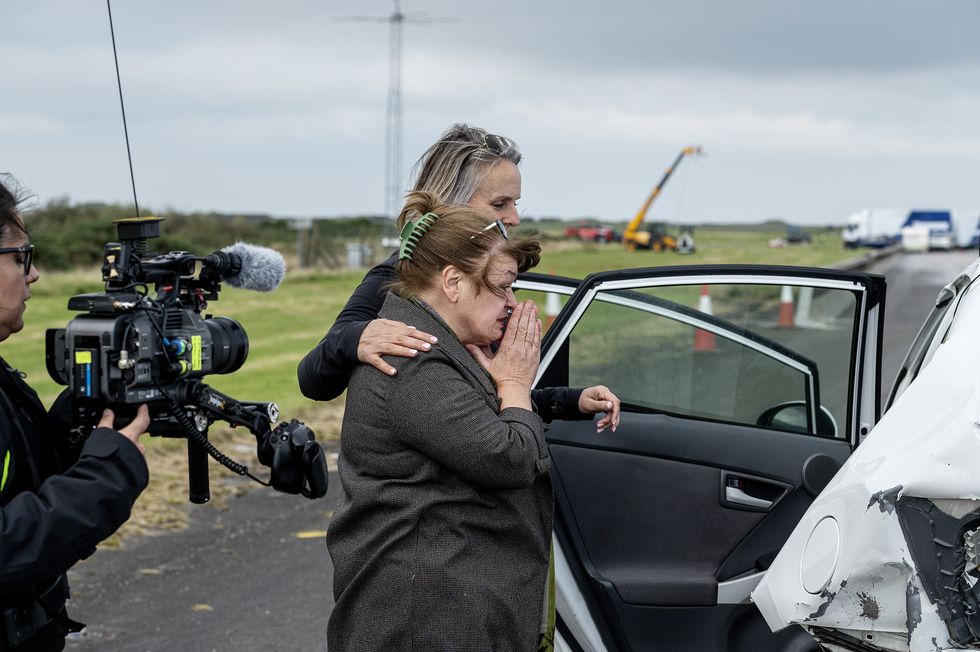 Volunteer driver Lynn peers inside the wrecked Prius to get a better look at the damage, and is comforted by Crash Analysis expert Janet Bahouth