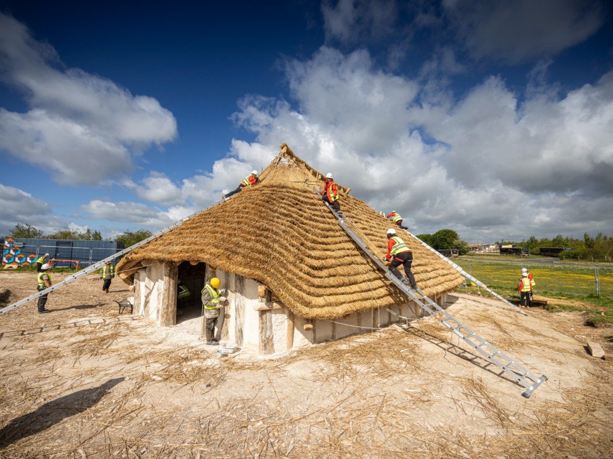 volunteers assisting in the construction of the Kusuma Neolithic Hall near Stonehenge in Wiltshire