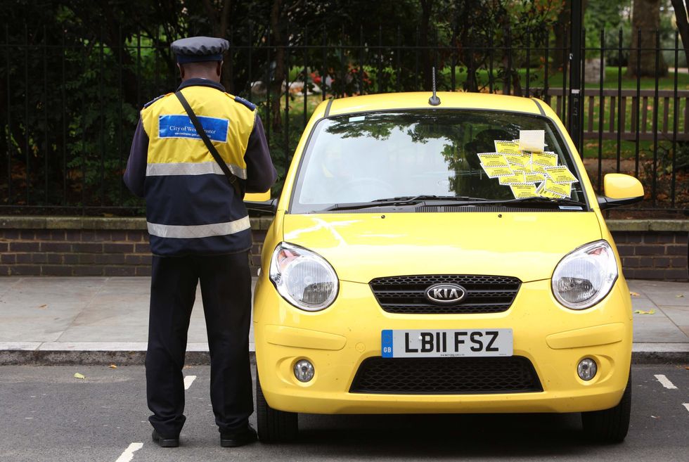 Warden handing out parking tickets in London