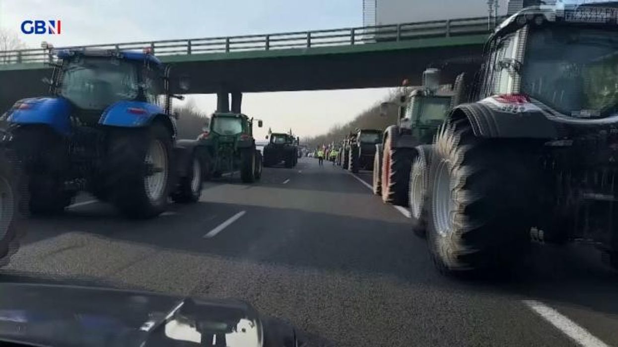 French protesters use tractor to smash down barricade as tear gas deployed by riot police