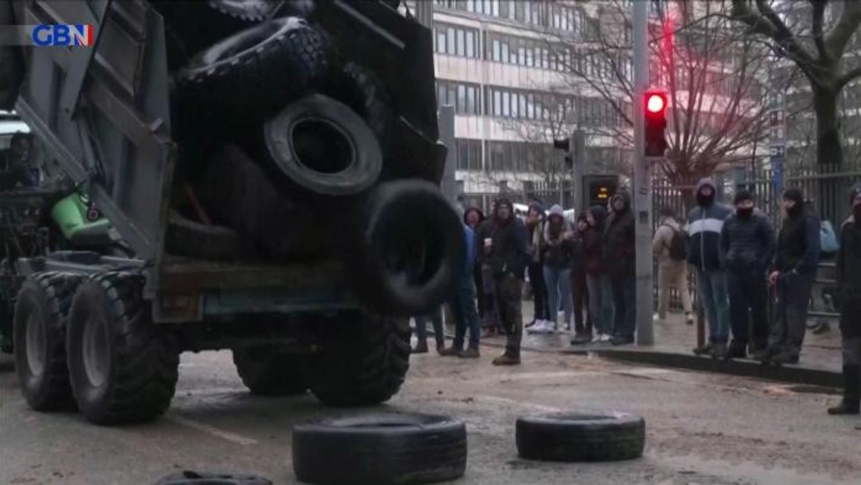 Riot police fire water cannon after protesting farmers light BONFIRE outside EU HQ