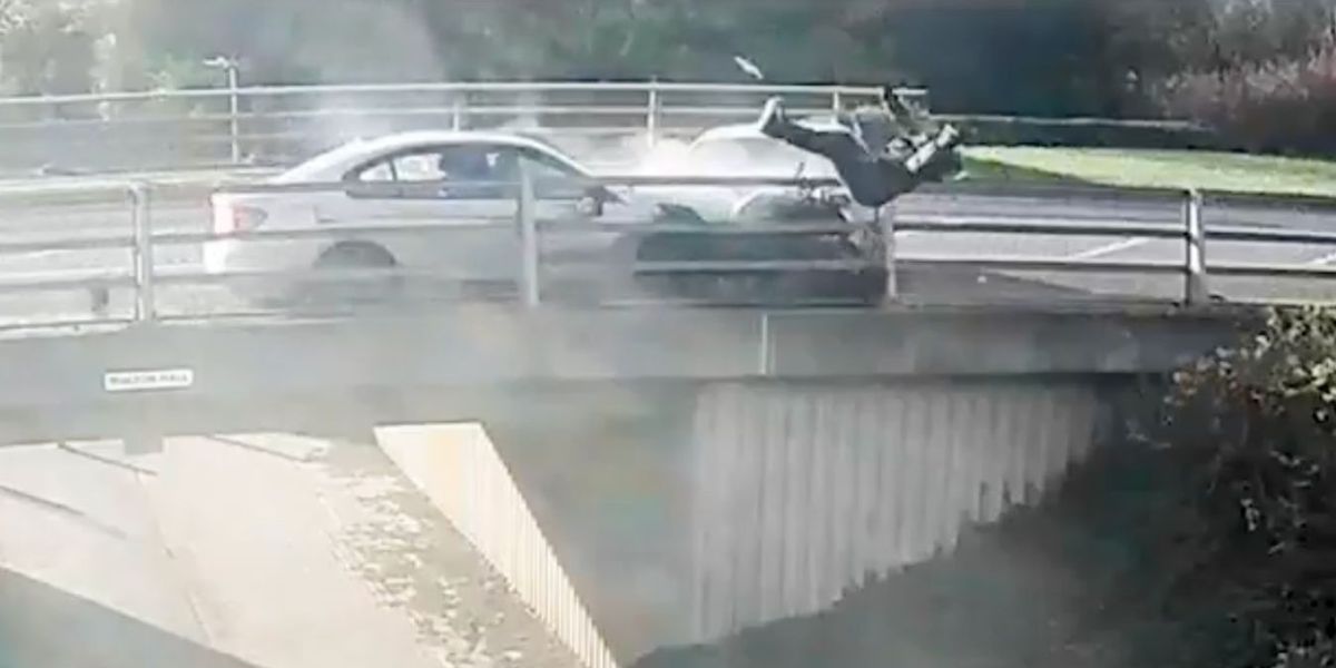 NextImg:Biker flung over bridge in dramatic footage as two cars crash in head-on collision