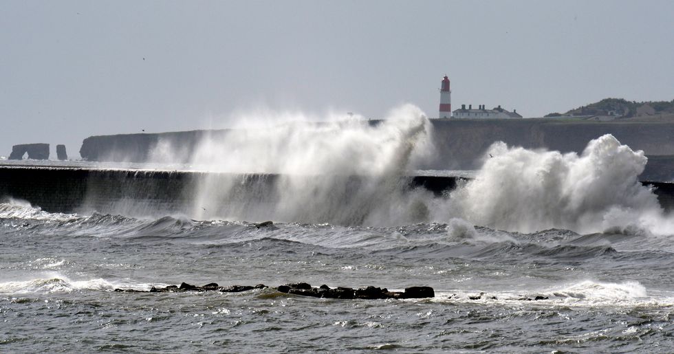 Waves crash against the promenade in Marsden
