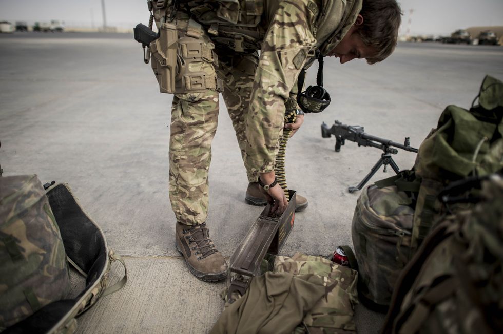 Weapons and ammunition are checked as some of the last British troops head towards the flight line as they prepare to leave Camp Bastion, Helmand Province