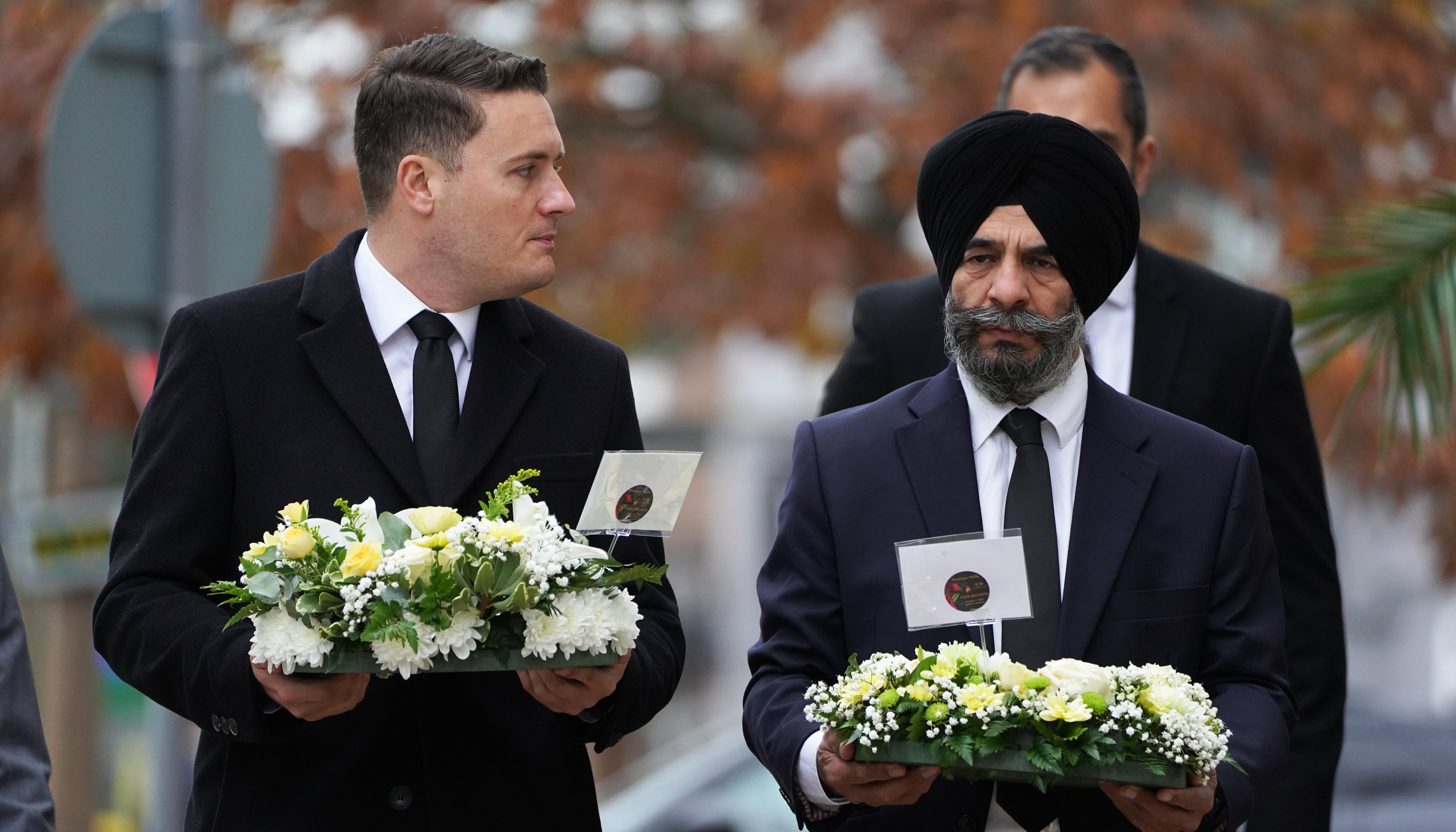 Wes Streeting, Labour MP for Ilford North, and Jas Athwal, Leader of Redbridge London Borough Council, carry flowers as they arrive at the scene near Belfairs Methodist Church in Eastwood Road North, Leigh-on-Sea.
