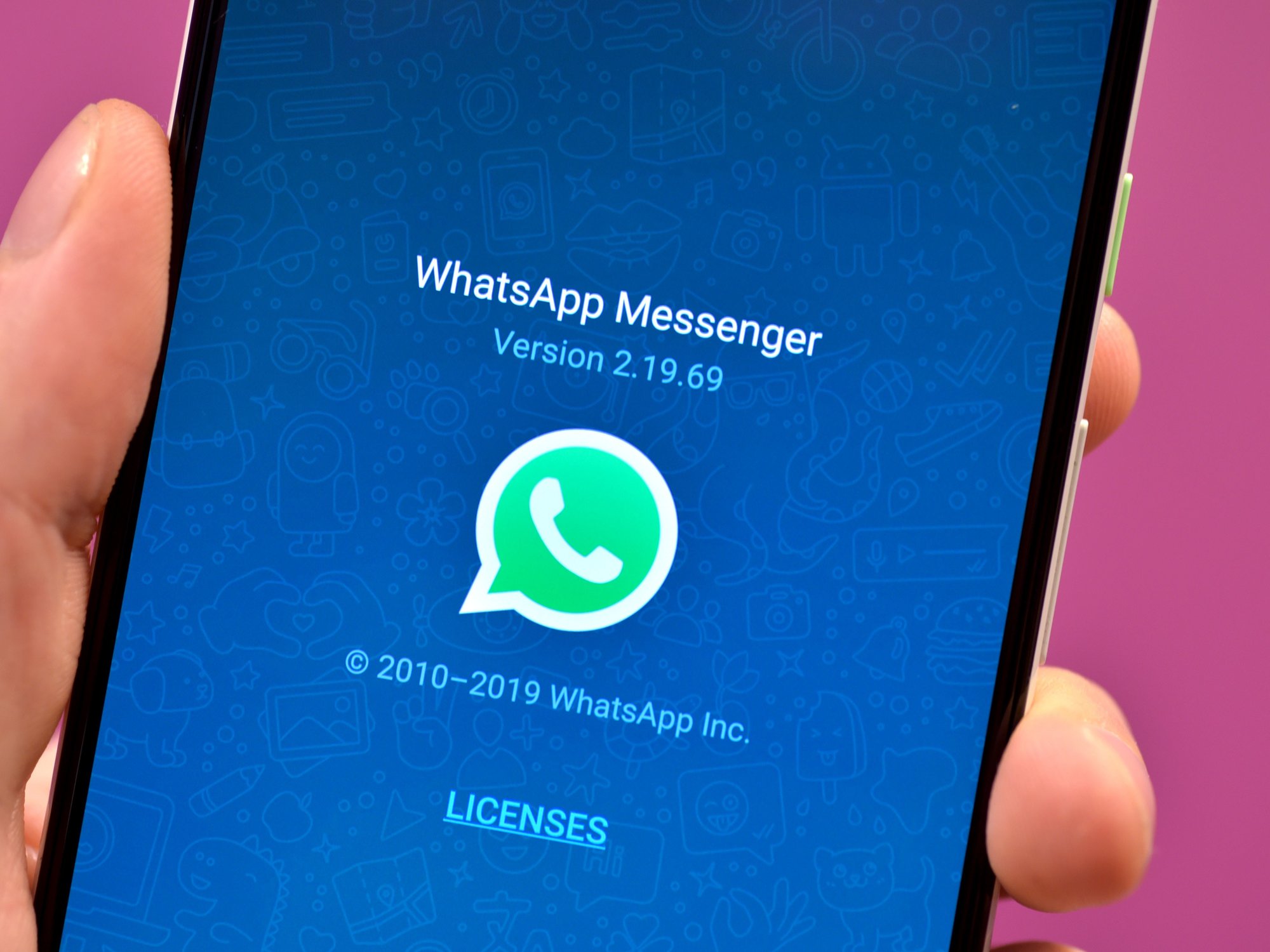 WhatsApp loading screen is shown on an Android phone with a pink background