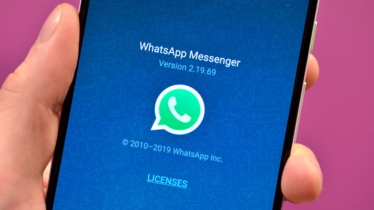 WhatsApp loading screen is shown on an Android phone with a pink background