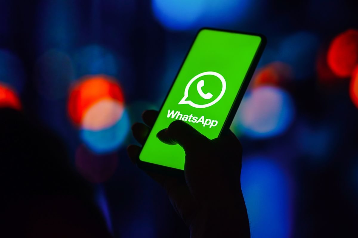 whatsapp logo pictured on a smartphone screen held in someone's hand 