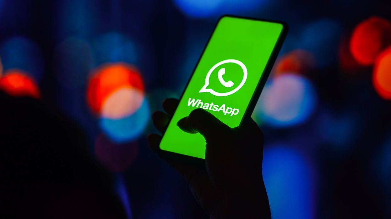 whatsapp logo pictured on a smartphone screen held in someone's hand