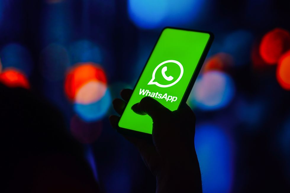 whatsapp logo pictured on a smartphone screen held in someone's hand