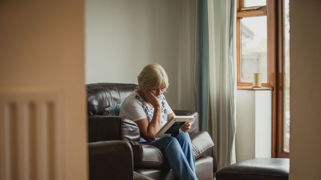 Widow looks at photo on sofa