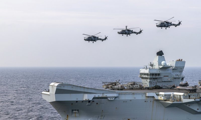 Wildcat Helicopters from 815 Naval Air Squadron fly past the HMS Prince of Wales