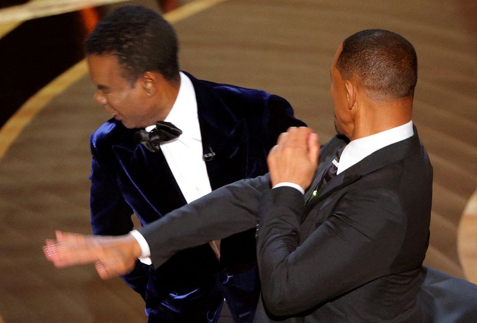 Will Smith (R) hits Chris Rock as Rock spoke on stage during the 94th Academy Awards in Hollywood, Los Angeles, California.