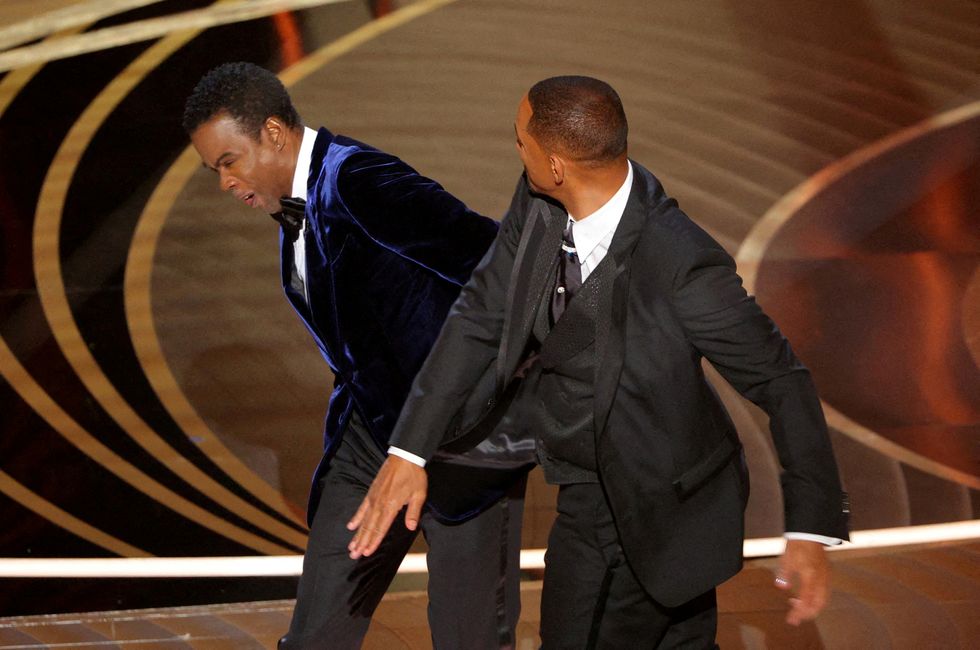 Will Smith (R) hits Chris Rock as Rock spoke on stage during the 94th Academy Awards in Hollywood