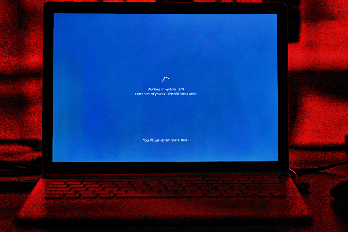 Windows 10 PC with the Windows Update screen showing progress on-screen
