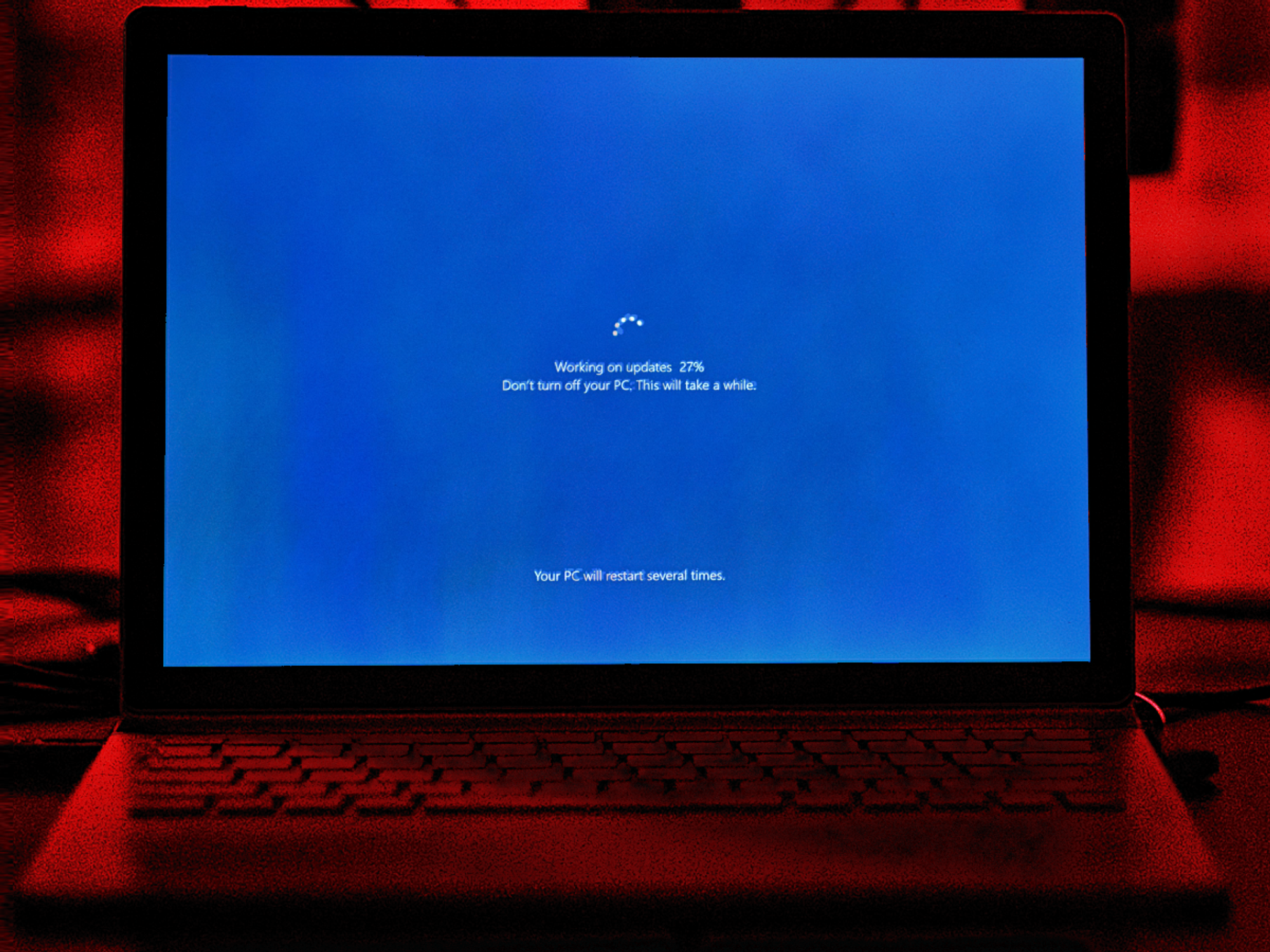 Windows 10 PC with the Windows Update screen showing progress on-screen