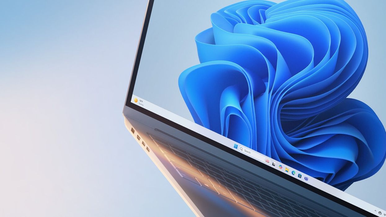 windows 11 laptop at a dramatic angle with the standard wallpaper on show