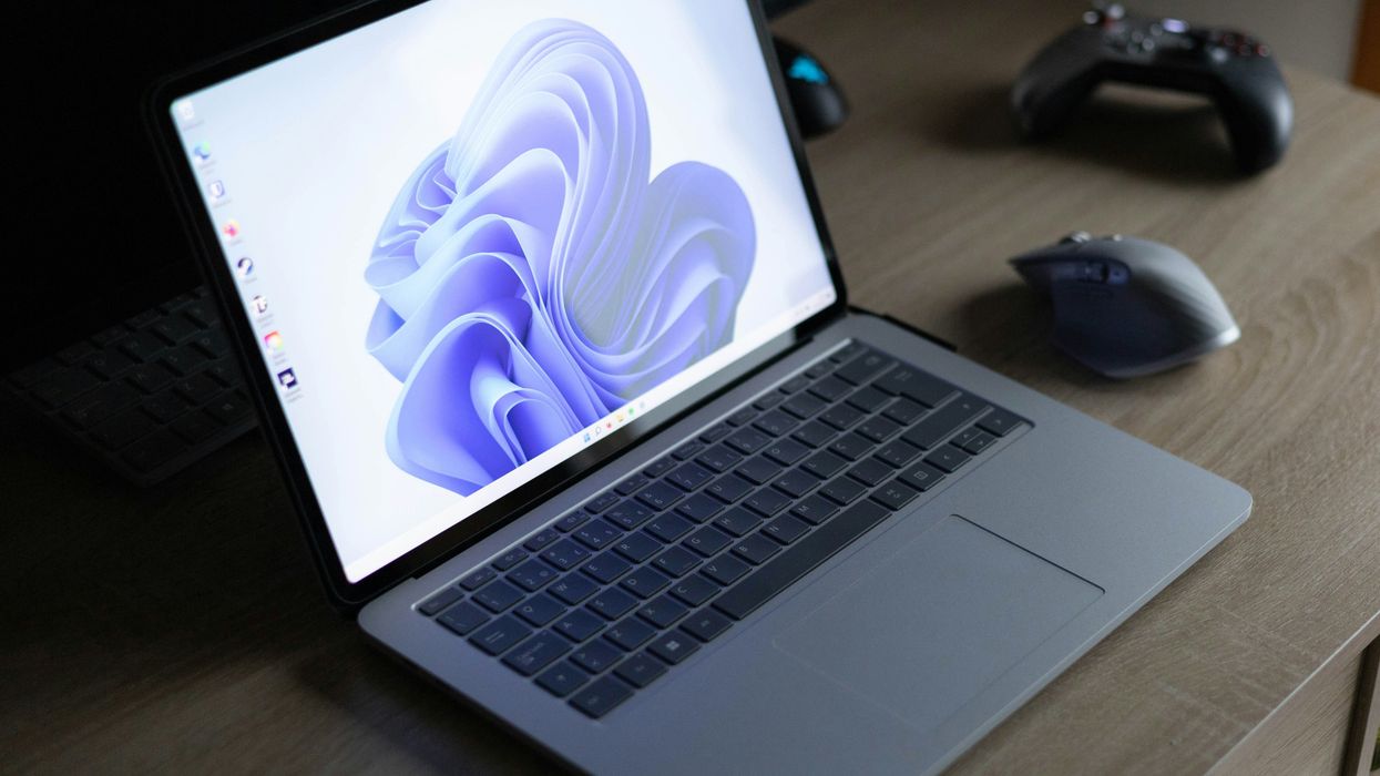 windows 11 laptop pictured on a desk with a mouse and xbox controller beside it