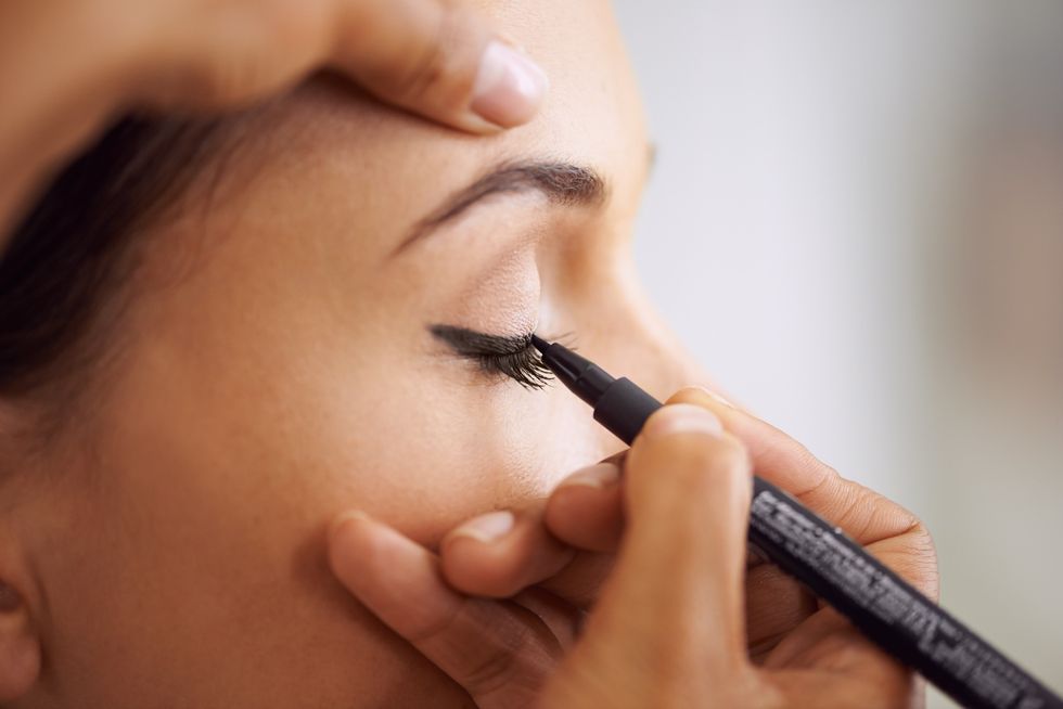 Woman applying black eyeliner