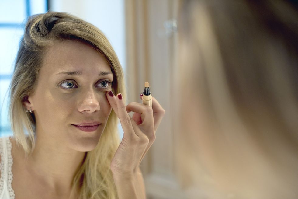 Woman applying concealer