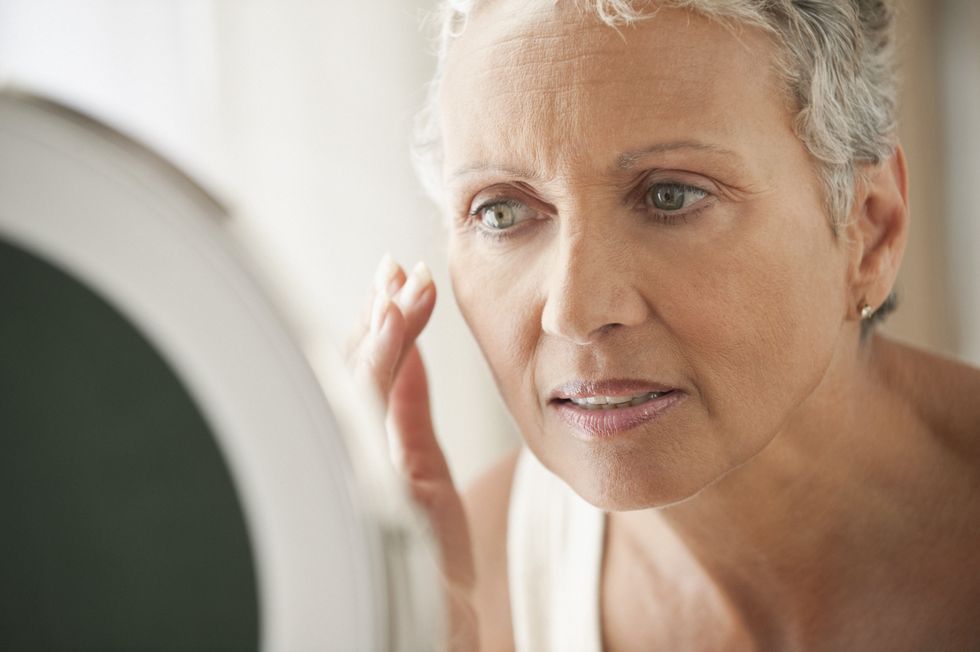 woman applying cream to face