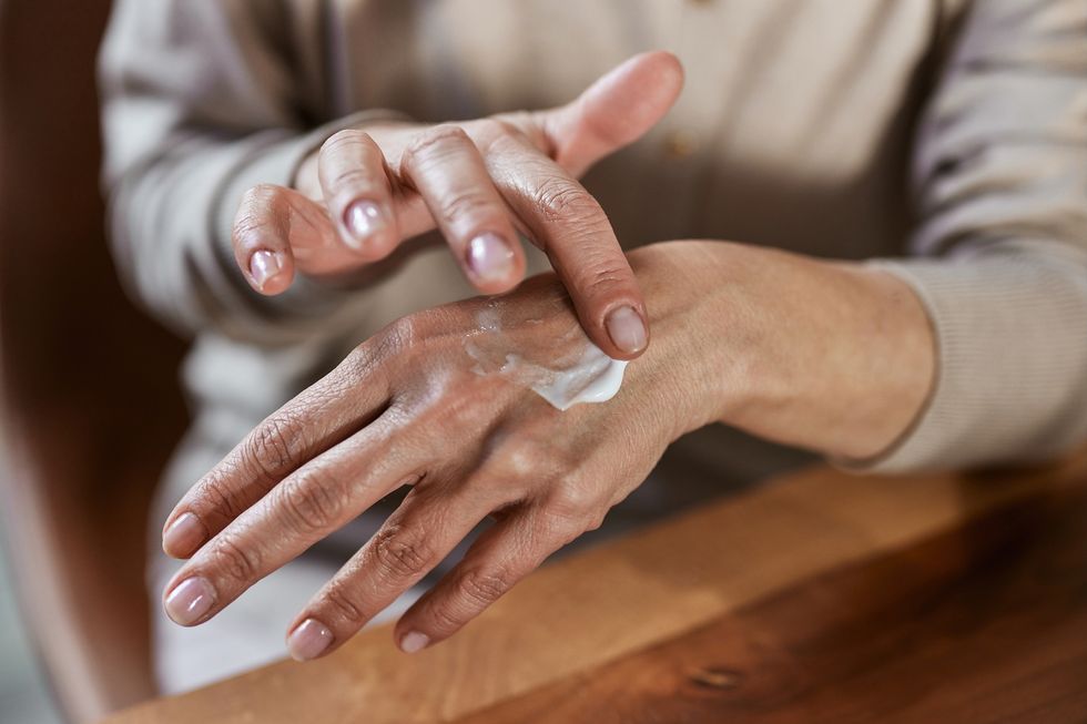 Woman applying cream to her hands