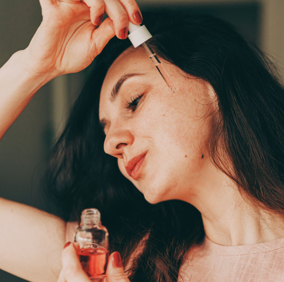 woman applying essence to face