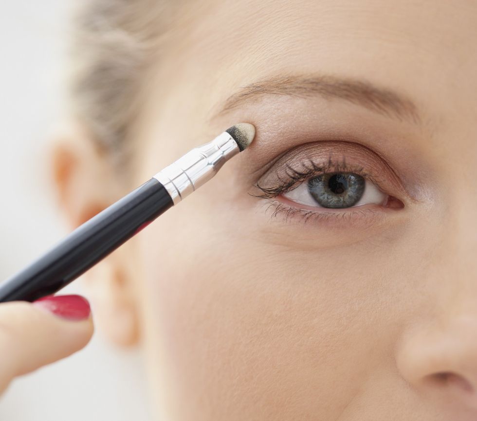 Woman applying eyeshadow on eyes