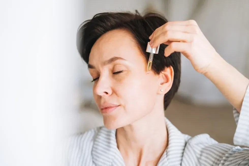 Woman applying face serum