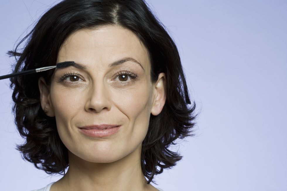 Woman applying makeup on eyebrows