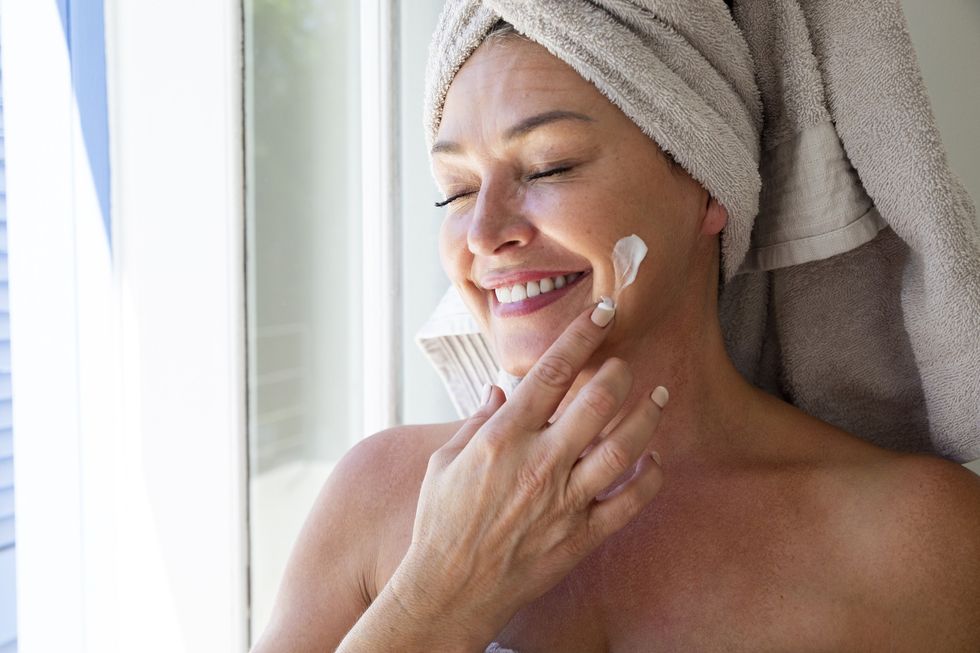 Woman applying moisturiser to her face