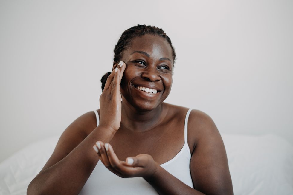 Woman applying moisturiser